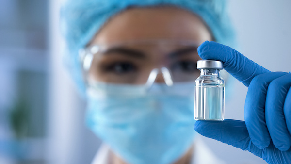 Lady scientist looking at ampoule with new medication, vaccination development